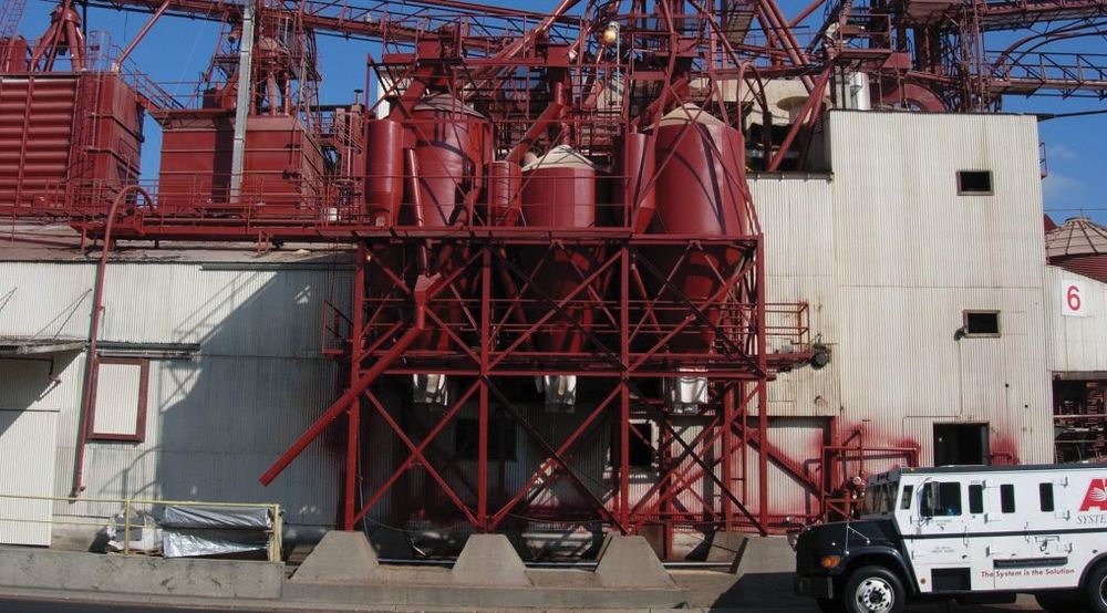 Red-coated processing structure with hoppers and steel framework at an industrial plant