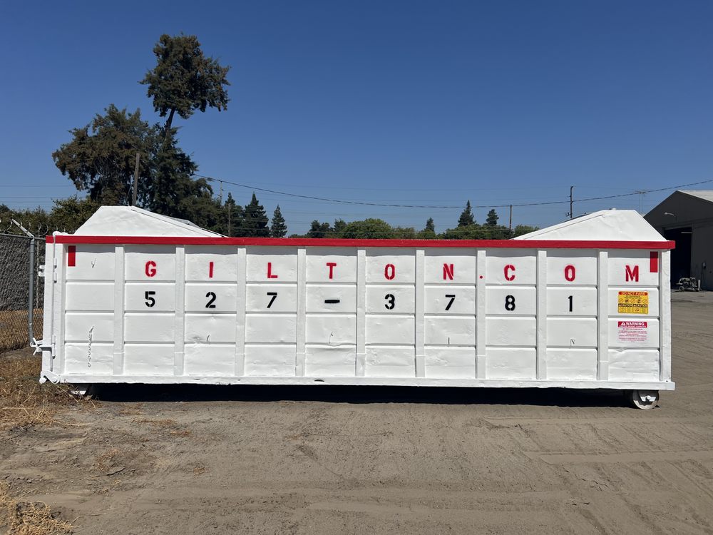 Roll-off container refinished in white with red lettering and numbering