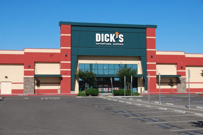 Big-box retail storefront exterior painted in red, green, and tan