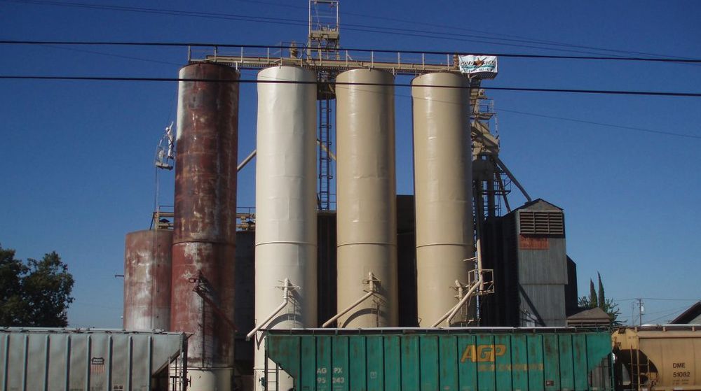 Silo bank with newly coated silos beside a corroded uncoated silo