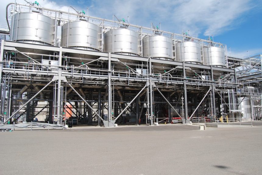 Stainless process tanks on a coated structural steel platform at a processing plant