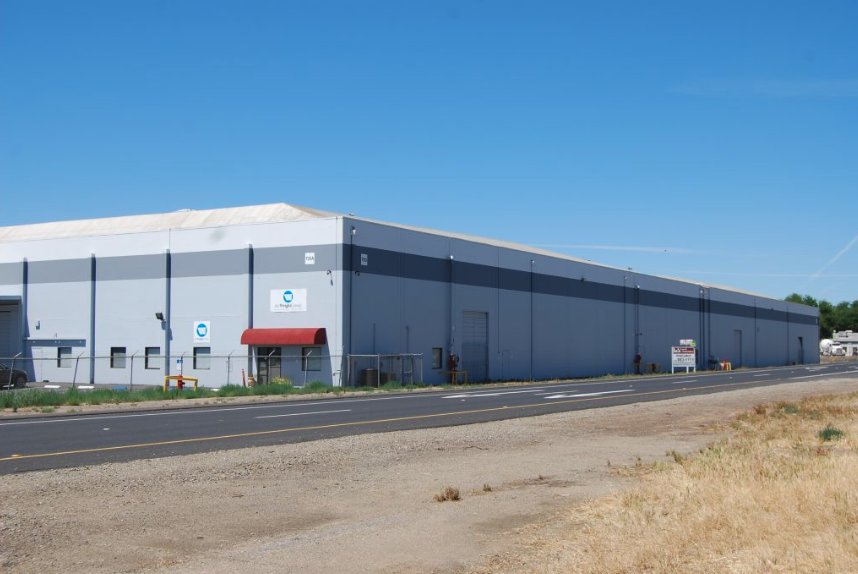 Long warehouse and distribution building exterior painted in two-tone gray
